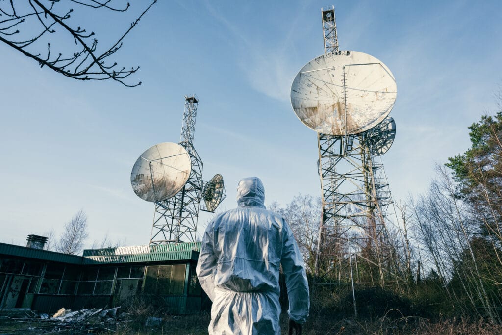 Photo d’urbex d’Augustin Cervoni, prise lors d’une exploration dans une station radar Atlas abandonnée, avec un personnage blanc. Photos de jour et de nuit, avec mise en scène. Photographie d’urbex artistique.